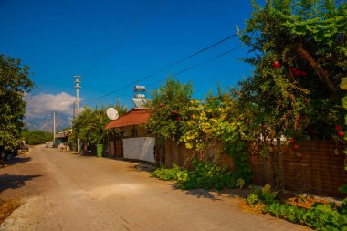 Antalya, Kemer 'de güneşli bir günde vinç ve portakalların yetiştiği dağların ve tarlaların güzel manzarası..