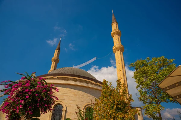KEMER, TURKEY: Güzel cami manzarası Kemer Cami ve mavi gökyüzünün arka planında çiçekler.