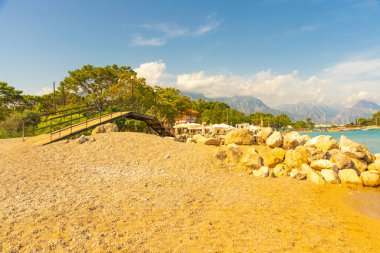 KEMER, TURKEY: güneşli bir günde Kemer plajında kanal yakınında küçük bir köprü görüntüsü.