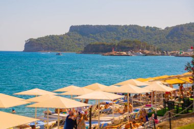 KEMER, TURKEY: Türkiye 'nin Akdeniz kıyısındaki popüler turistik beldesi Kemer' de güneşli bir günde plajın güzel manzarası.