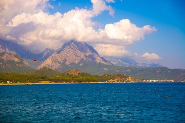 KEMER, TURKEY: Güneşli bir günde Türkiye 'nin Akdeniz kıyısındaki popüler turizm beldesi Kemer' in güzel deniz ve dağ manzarası.
