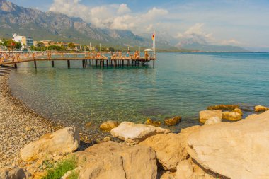 KEMER, TURKEY: Türkiye 'nin Akdeniz kıyısındaki popüler turizm beldesi Kemer' de güneşli bir günde plajda ve dağlarda güzel manzara.