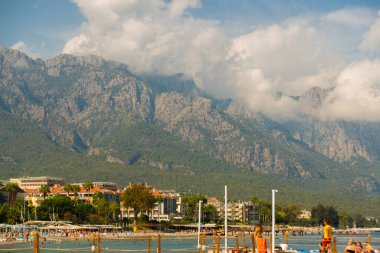 KEMER, TURKEY: Türkiye 'nin Akdeniz kıyısındaki popüler turizm beldesi Kemer' de güneşli bir günde Kemer 'deki ünlü Central Beach.