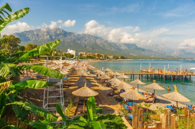 Türkiye 'nin Akdeniz kıyısındaki popüler turizm beldesi Kemer' in sahilindeki iskelede şemsiye ve güneş panzesi.
