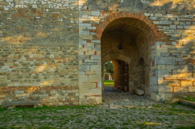 APOLONYA, ALBANIA: Arnavutluk 'un Apollonia kentindeki Aziz Mary Manastırı' nın antik taş duvarı ve girişi.
