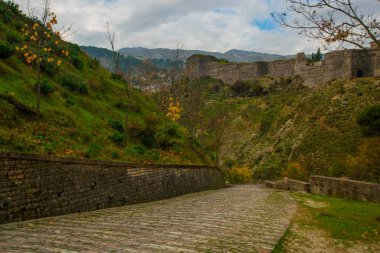 GjIROKASTRA, ALBANIA: Bulutlu bir günde Cirokastra 'daki eski kale ve duvarların manzarası. UNESCO Dünya Mirası Alanı.