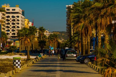 VLORA / VLORE, ALBANIA: Arnavutluk 'un Vlora kentinde yeni çağdaş binalar ve palmiye ağaçlı bir yol.