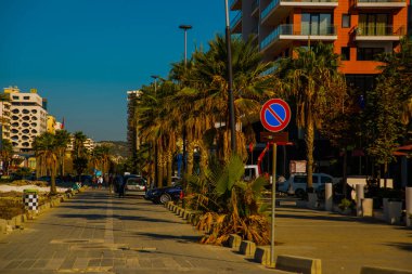 VLORA / VLORE, ALBANIA: Arnavutluk 'un Vlora kentinde yeni çağdaş binalar ve palmiye ağaçlı bir yol.