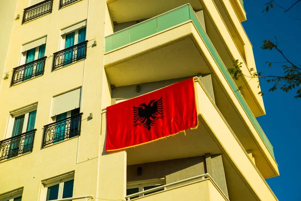 VLORA-VLORE, ALBANIA: Albánská vlajka na balkóně nových moderních budov ve Vloře. — Stock fotografie