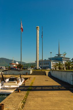 BATUMI, GEORGIA: Georgi 'nin Adjara bölgesinde bir yaz günü rıhtımlara demirlemiş bir yolcu istasyonu ve tekneleri ile Batumi limanının deniz manzarası.