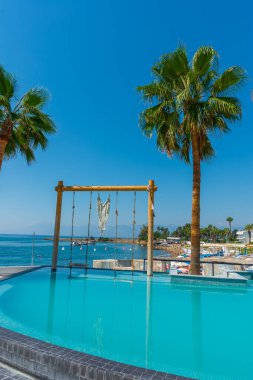 Türkiye 'nin Antalya kentindeki Akdeniz kıyısında güneşli bir günde Fosforlu plajında havuz ve salıncak