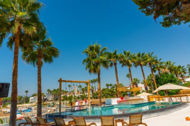 Türkiye 'nin Antalya kentindeki Akdeniz kıyısında güneşli bir günde Fosforlu plajında havuz ve salıncak