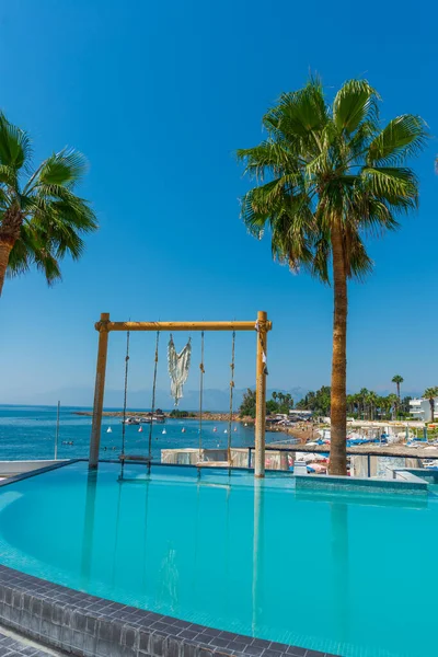 Türkiye 'nin Antalya kentindeki Akdeniz kıyısında güneşli bir günde Fosforlu plajında havuz ve salıncak