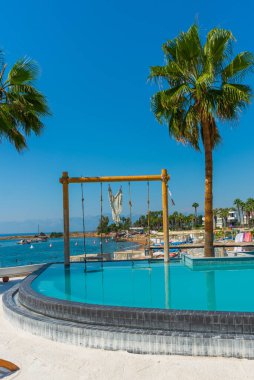 Türkiye 'nin Antalya kentindeki Akdeniz kıyısında güneşli bir günde Fosforlu plajında havuz ve salıncak