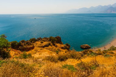 Türkiye 'nin Antalya kentinde güneşli bir yaz gününde Konyaalti plajında büyük bir kaya taşı.