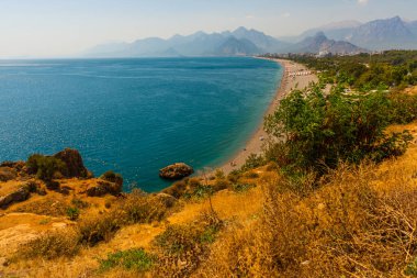 Türkiye 'nin Antalya kentinde güneşli bir yaz gününde Konyaalti plajında büyük bir kaya taşı.