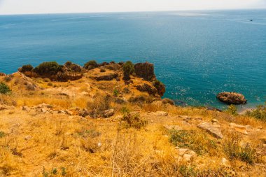 Türkiye 'nin Antalya kentinde güneşli bir yaz gününde Konyaalti plajında büyük bir kaya taşı.