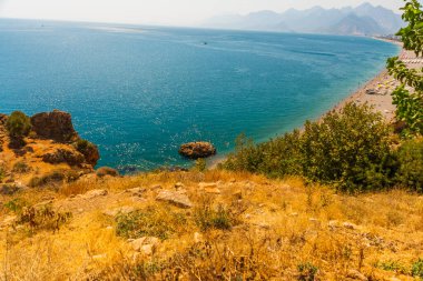 Türkiye 'nin Antalya kentinde güneşli bir yaz gününde Konyaalti plajında büyük bir kaya taşı.