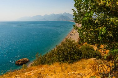 Türkiye 'nin Antalya kentinde güneşli bir yaz gününde Konyaalti plajında büyük bir kaya taşı.