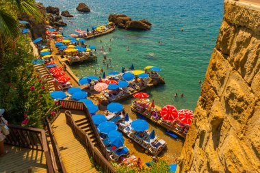 Mermerli sahilinde, Antalya 'nın merkezinde renkli şemsiyeler var. Popüler sahil beldesi Antalya 'nın Kaleici ilçesinde temiz mavi sulara sahip güzel bir sahil..