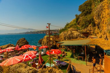 ANTALYA, TURKEY: Karaalioğlu Parkı 'ndaki kayalıklardaki Adalar Plajında kırmızı şemsiyeler, popüler sahil beldesi Antalya, Türkiye.