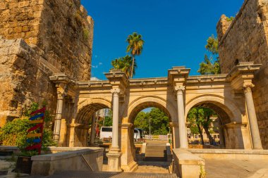 Arka planda mavi gökyüzünde Adrian Gate 'i görüyoruz. Mermer ve kireçtaşından antik yapılar, Antalya, Türkiye.
