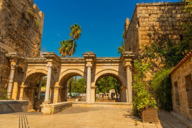 Arka planda mavi gökyüzünde Adrian Gate 'i görüyoruz. Mermer ve kireçtaşından antik yapılar, Antalya, Türkiye.