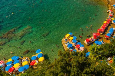 Mermerli sahilinde, Antalya 'nın merkezinde renkli şemsiyeler var. Popüler sahil beldesi Antalya 'nın Kaleici ilçesinde temiz mavi sulara sahip güzel bir sahil..