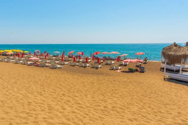 Türkiye 'nin Antalya kentinde güneşli bir yaz gününde, Lara plajında çardaklar, güneşlikler ve şemsiyeler.