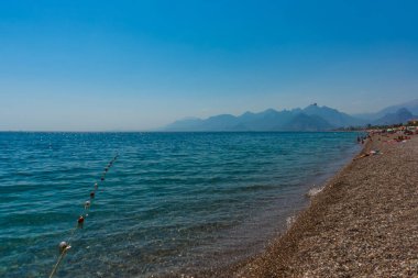 Türkiye 'nin Antalya kentinde güneşli yaz mevsiminde güzel Konyaalti plajı ve Akdeniz.