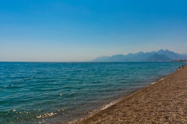 Türkiye 'nin Antalya kentinde güneşli yaz mevsiminde güzel Konyaalti plajı ve Akdeniz.