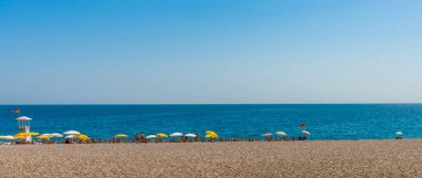 Türkiye 'nin Antalya kentinde güneşli yaz mevsiminde güzel Konyaalti plajı ve Akdeniz.