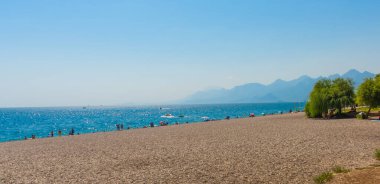 Türkiye 'nin Antalya kentinde güneşli yaz mevsiminde güzel Konyaalti plajı ve Akdeniz.