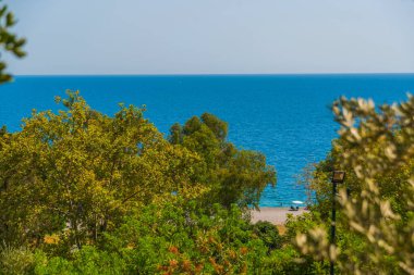 ANTALYA, TURKEY: Türkiye 'nin Antalya kentinde güzel ağaçlar ve Akdeniz, güneşli yaz mevsiminde Konyaalti plajı.