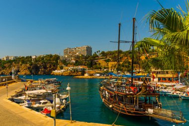 Antalya Antalya 'daki eski limanda deniz feneri ve güneşli bir yaz gününde gemi ve teknelerle liman, Türkiye.
