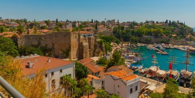 ANTALYA, TURKEY: Güneşli bir yaz gününde Antalya 'daki eski limanın ve limanın gemi ve tekneli üst manzarası, Türkiye.