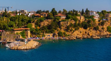 ANTALYA, TURKEY: Güneşli bir yaz gününde Antalya limanında eski liman ve turist tekneleri ve korsan gemileri için iskele manzarası.