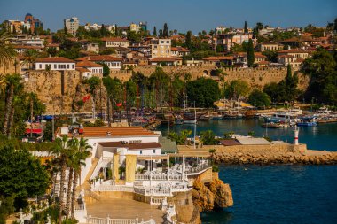 ANTALYA, TURKEY: Güneşli bir yaz gününde Antalya limanında eski liman ve turist tekneleri ve korsan gemileri için iskele manzarası.