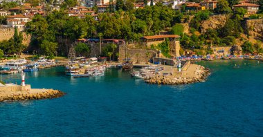 ANTALYA, TURKEY: Güneşli bir yaz gününde Antalya limanında eski liman ve turist tekneleri ve korsan gemileri için iskele manzarası.