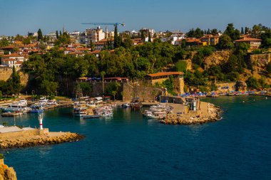 ANTALYA, TURKEY: Güneşli bir yaz gününde Antalya limanında eski liman ve turist tekneleri ve korsan gemileri için iskele manzarası.