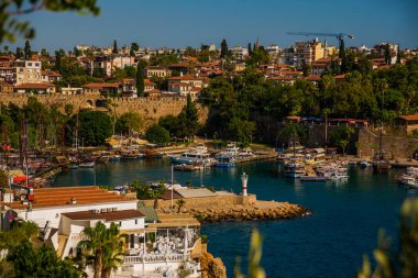 ANTALYA, TURKEY: Güneşli bir yaz gününde Antalya limanında eski liman ve turist tekneleri ve korsan gemileri için iskele manzarası.