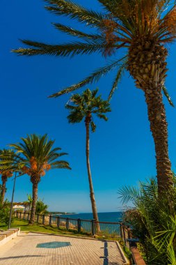 Mavi gökyüzünün arka planında güneşli bir yaz gününde, Akdeniz kıyısındaki gezinti güvertesinden manzarayı seyret..