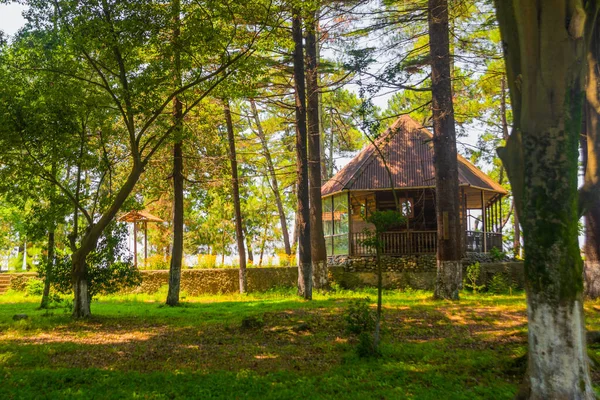 KOBULETI, GEORGIEN: Orthodoxe Holzkirche in einem schattigen Park an einem sonnigen Sommertag. — Stockfoto