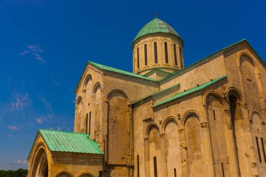 KUTAISI, GEORGIA: Güneşli bir yaz gününde mavi gökyüzüne karşı Bagrati 'nin eski Ortodoks Katedrali manzaralı manzara.