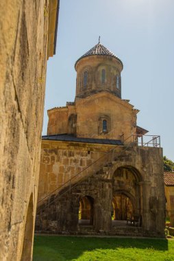 KUTAISI, GEORGIA, IMERETI: Güneşli bir yaz gününde Gelati Ortodoks manastırındaki eski taş çan kulesinin manzarası. UNESCO tarafından korunuyor..