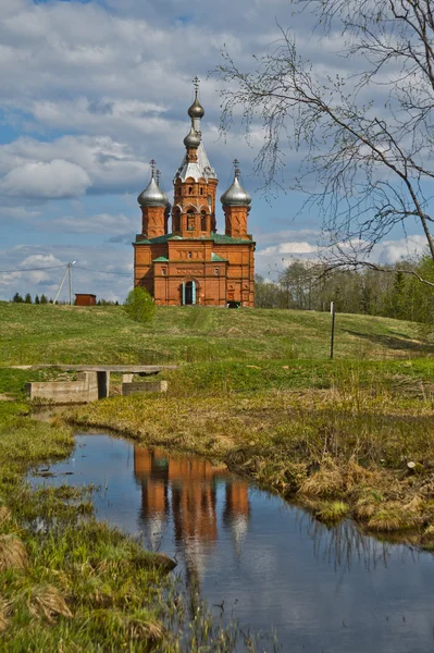 Een bakstenen kerk op het water in Rusland — Stockfoto