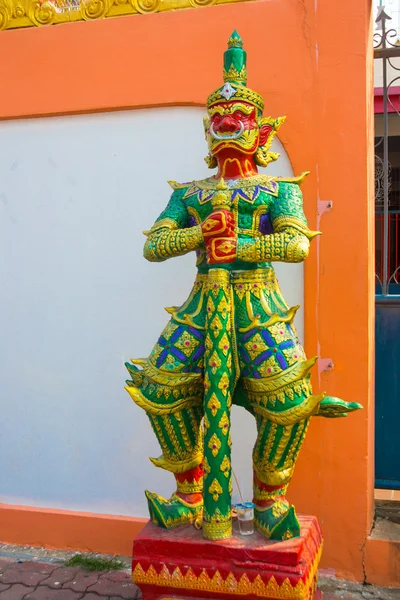 Wielobarwne rzeźby wojownika z mieczem z czerwoną twarzą w buddyjskiej świątyni. Nakhon Ratchasima. Tajlandia. — Zdjęcie stockowe