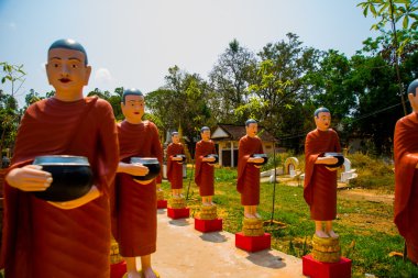 Rahipler kase elinde kırmızı giysili heykelleri. Siemreap, Kamboçya.