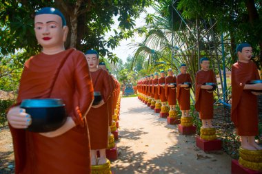 Rahipler kase elinde kırmızı giysili heykelleri. Siemreap, Kamboçya.