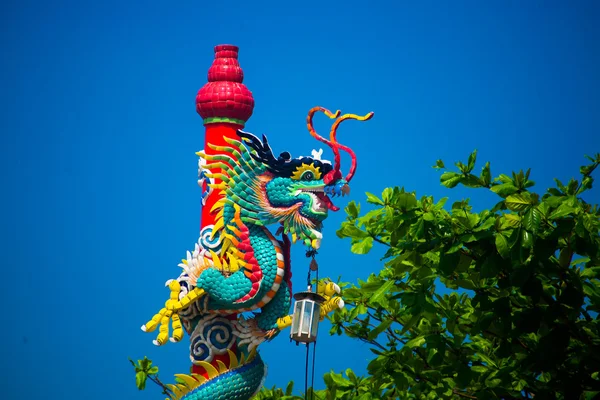En staty av en drake på en stolpe. Kinesiska röda lyktan. Kinesiskt tempel. — Stockfoto